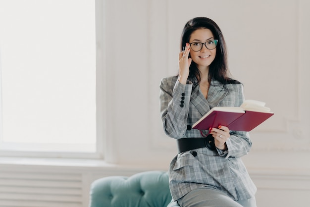 Belle femme brune écrit dans un bloc-notes