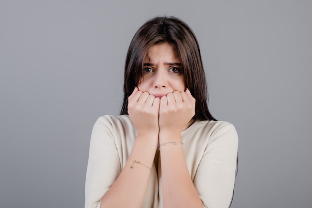 Belle femme brune effrayée et effrayée isolée sur gris