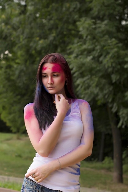 Belle femme brune avec de la poudre colorée posant dans la rue