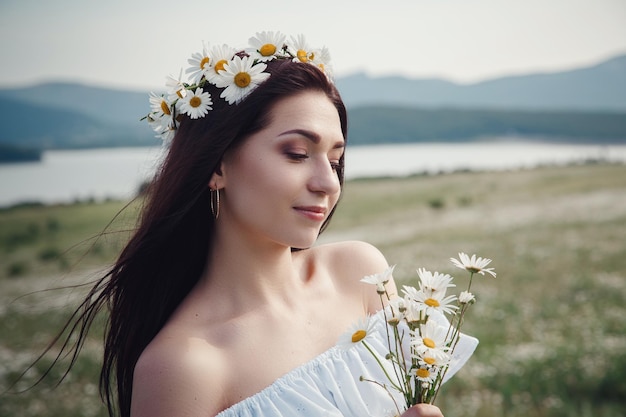 Belle femme brune profite du printemps dans un champ de marguerites