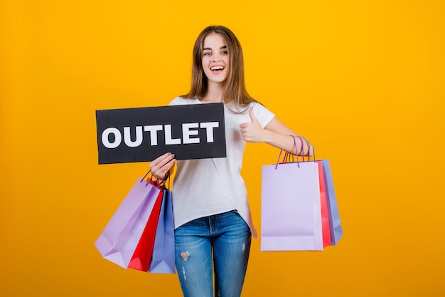 Belle femme brune avec des sacs colorés et bannière de signe de sortie de texte de fond isolé sur jaune