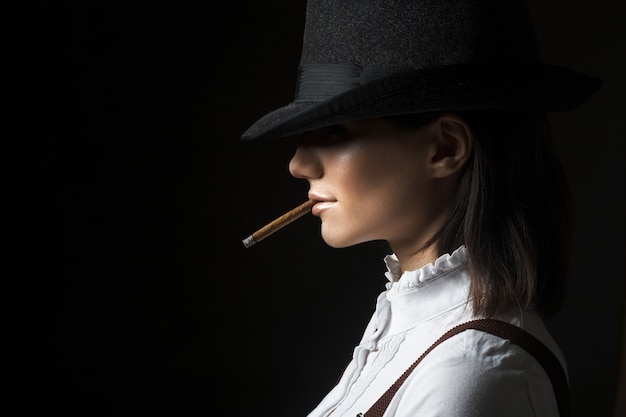 Belle femme brune sexy en cigarette fumer chapeau