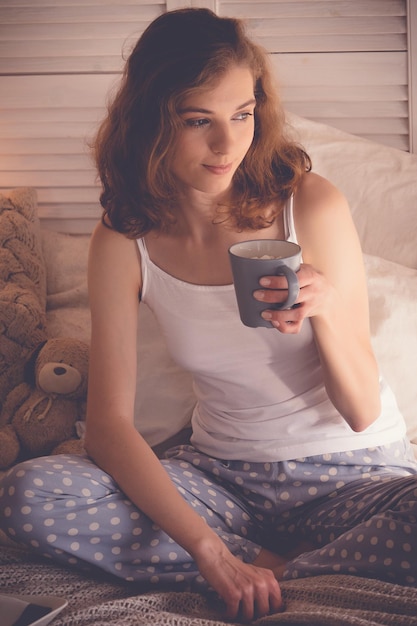 Belle femme buvant un café dans son lit Concept de style de vie