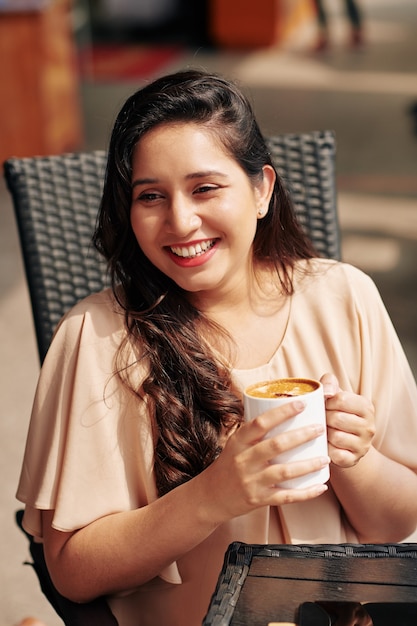 Belle femme buvant un cappuccino