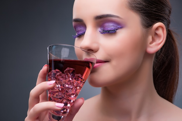 Belle femme buvant un cocktail rouge