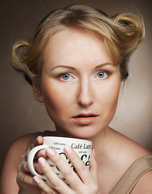 Belle femme buvant du café. tourné en studio.