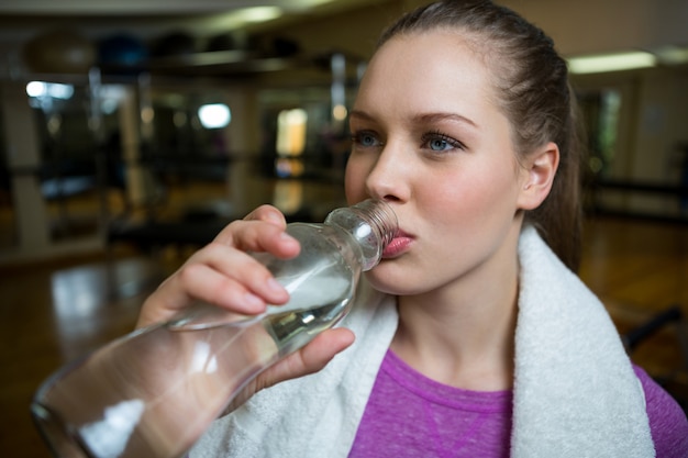 Belle femme buvant de l'eau après l'entraînement