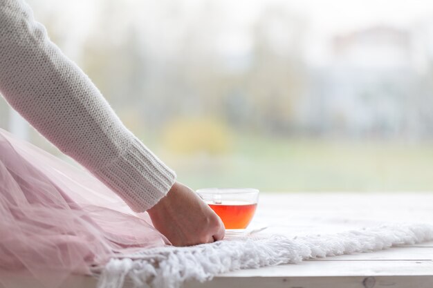 Belle femme buvant une tasse de thé dans la chambre le matin