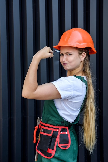 Belle femme en casque et combinaison tenant la clé de fixation sur les yeux