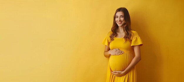 Photo une belle femme caucasienne enceinte en robe jaune tenant les mains sur le ventre