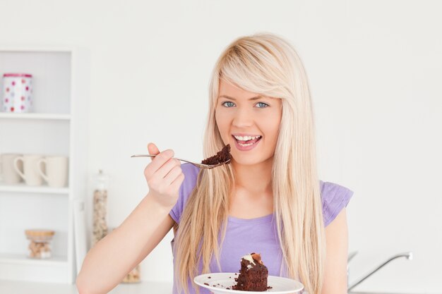 Belle femme caucasienne mangeant le gâteau