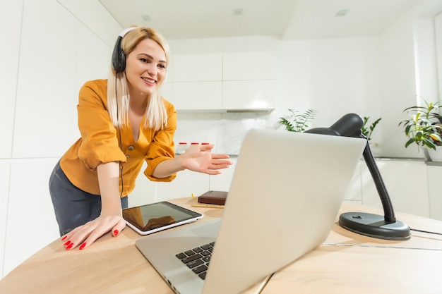 Belle femme caucasienne travaillant sur ordinateur portable. Fond de cuisine.