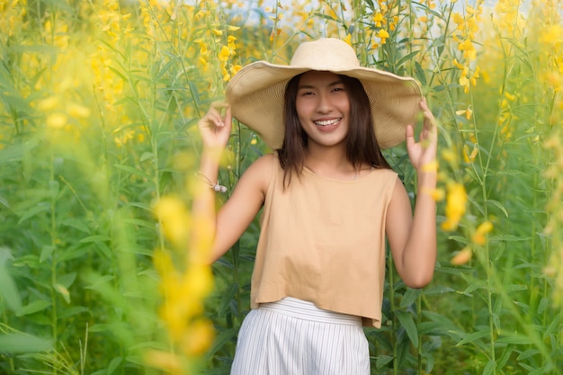 Belle femme avec un champ de fleurs Sunhemp