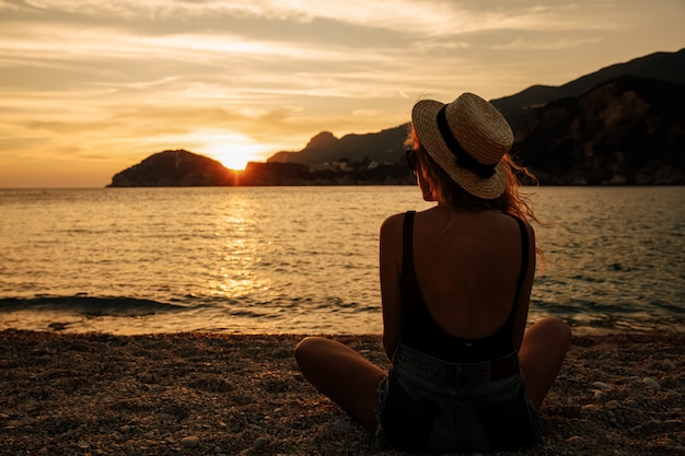 Belle femme avec un chapeau près de la mer