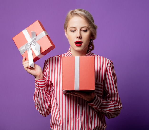 Belle femme en chemise rayée rouge avec boîte-cadeau