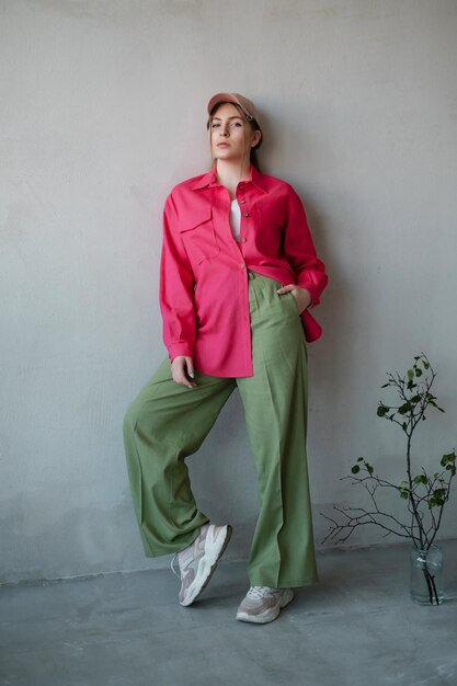 Belle femme en chemise rose au mur de béton