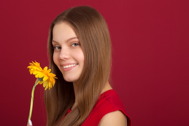 Belle femme avec une chemise rouge et une fleur