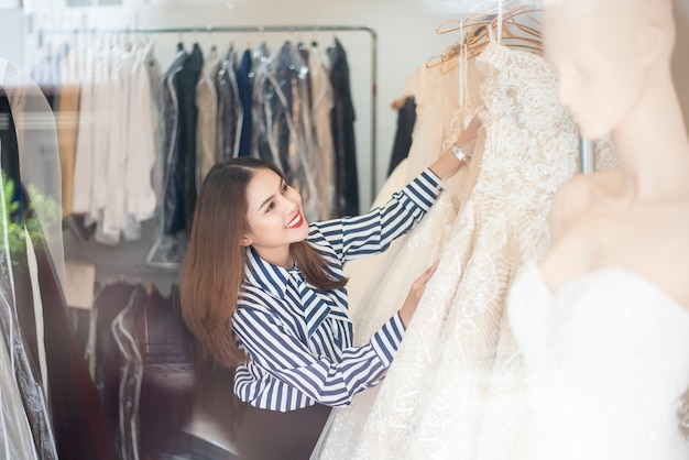 Belle femme cherche robe de mariée dans la boutique de mariage