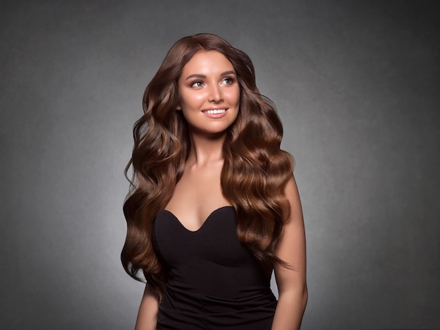 Belle femme cheveux bouclés coiffure féminine. Prise de vue en studio.