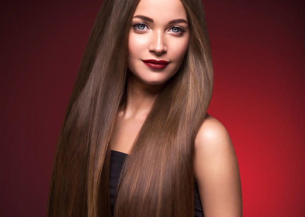 Belle femme cheveux longs lisse brune coiffure beauté cheveux sains modèle féminin portrait. Prise de vue en studio.