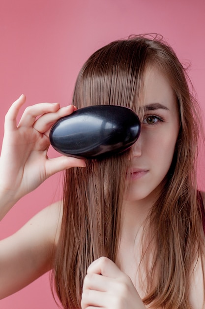 Belle femme coiffe ses cheveux longs en bonne santé.