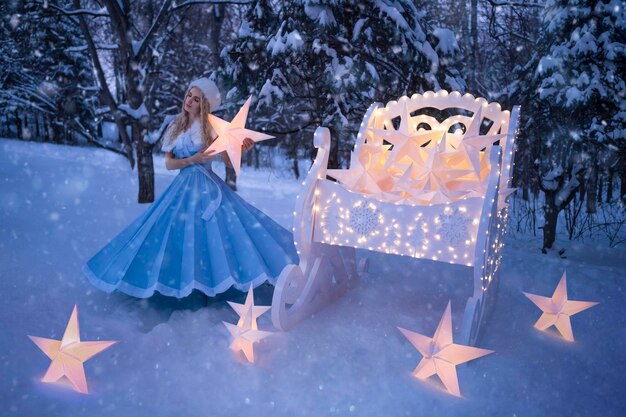 Photo belle femme comme fille des neiges avec traîneau et étoiles