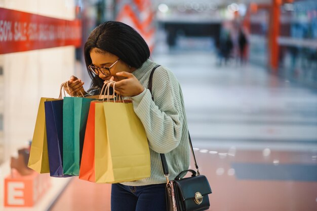 Photo belle femme commerçante souriante et tenant des sacs