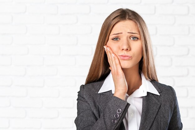 Belle femme confuse avec douleur sur fond