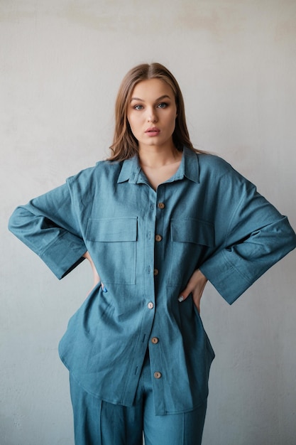 Belle femme en costume bleu au mur de béton