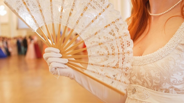 Belle femme en costume de boule vintage femme agitant un ventilateur se bouchent