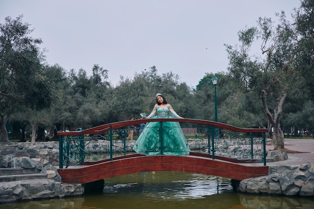 Belle femme en costume de princesse robe de bal sur un pont