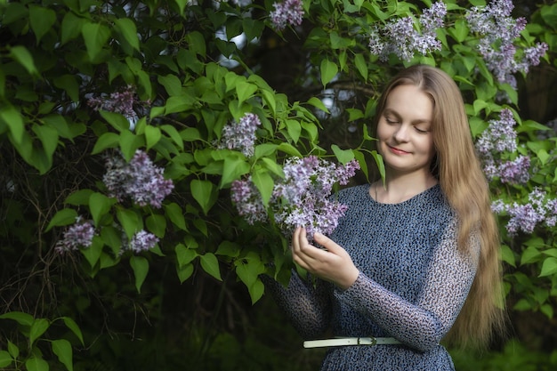 Belle femme avec une couronne de fleurs lilas Fille dans une couronne de lilas au printemps