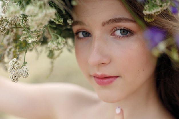 Belle femme avec une couronne de fleurs sur la tête.