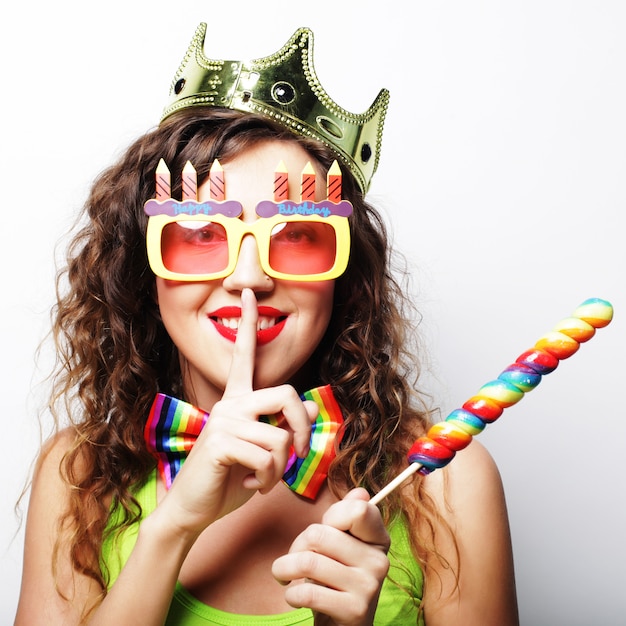 Belle femme avec une couronne et des lunettes de soleil drôles