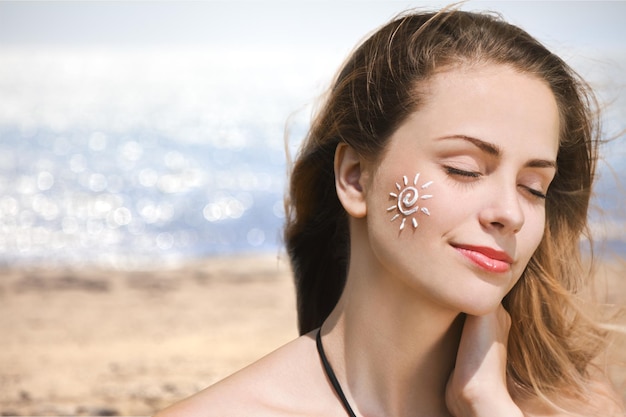 Belle femme avec crème solaire sur la crème solaire