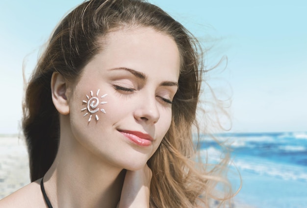 Belle femme avec crème solaire sur la crème solaire