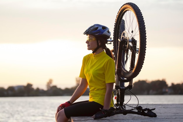 Belle femme cycliste avec un vélo sur la nature Mode de vie sain et sport Loisirs et passe-temps