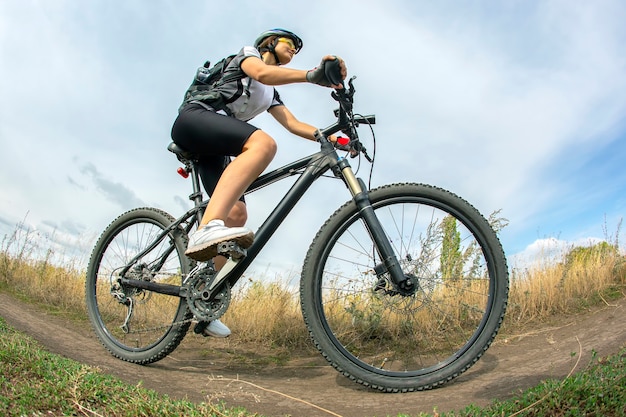 Belle femme cycliste avec un vélo sur la nature