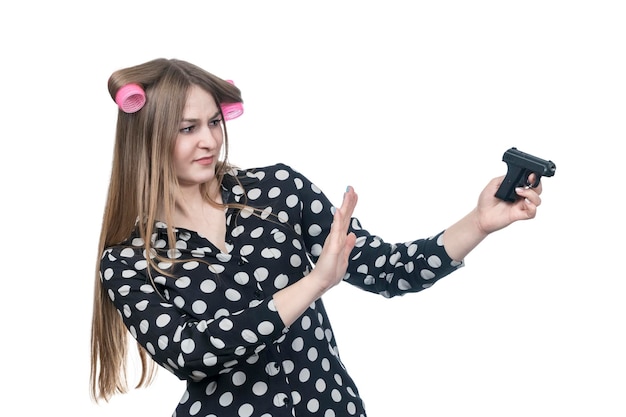 belle femme dans les bigoudis se déplace d'armes à feu dans le dégoût isolé sur fond blanc