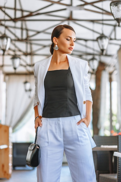 Belle femme dans un costume blanc dans un restaurant