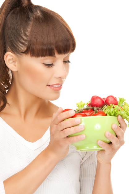 belle femme dans la cuisine avec des tomates..