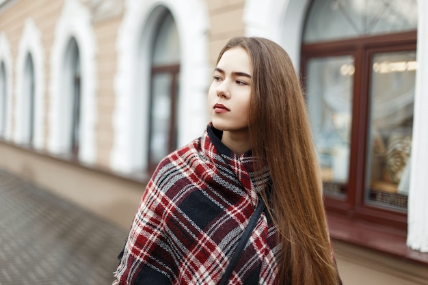 Belle femme dans une écharpe rayée vintage dans la rue