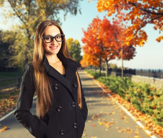 Belle femme dans le parc d'automne avec le feuillage rouge