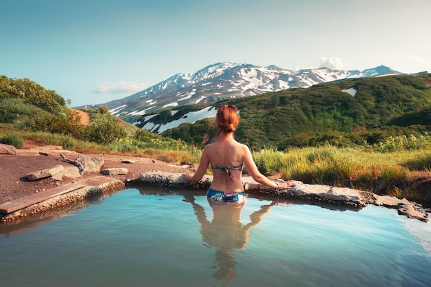 Belle femme dans une piscine thermale naturelle avec vue sur la montagne Sources thermales chaudes dans la péninsule du Kamtchatka Russie Concept de voyage d'été