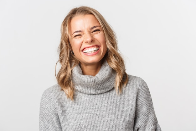 Belle femme dans un pull gris posant