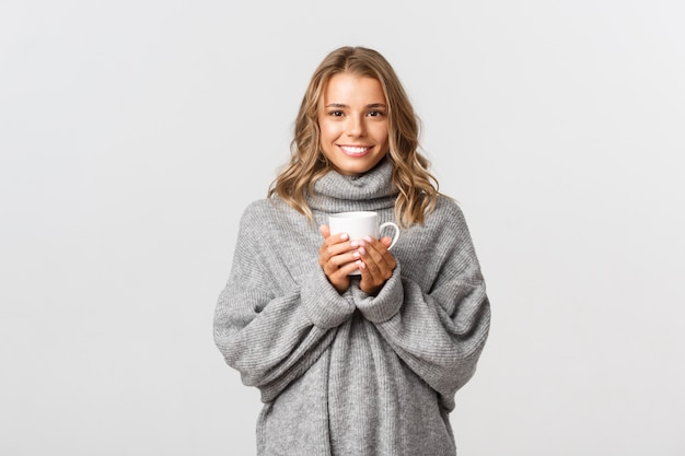 Belle femme dans un pull gris posant