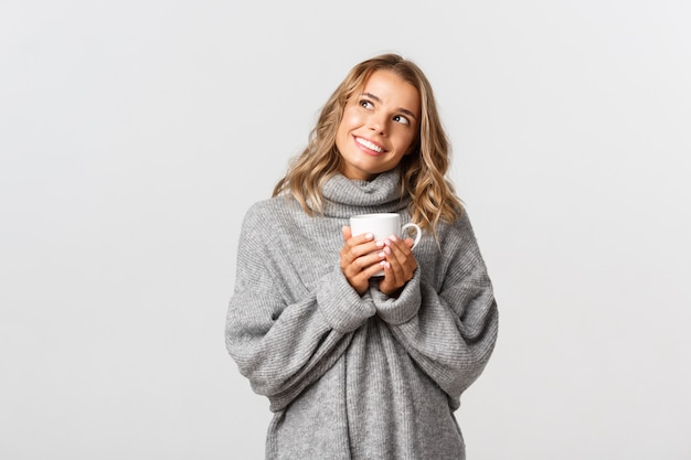 Belle femme dans un pull gris posant