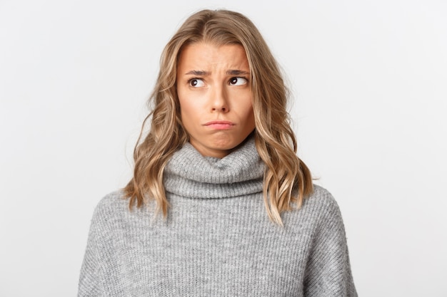 Belle femme dans un pull gris posant