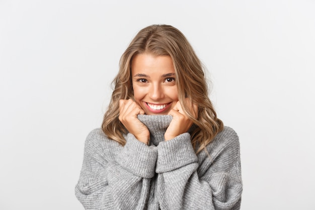 Belle femme dans un pull gris posant