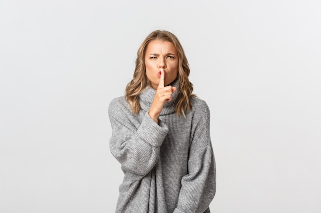 Belle femme dans un pull gris posant